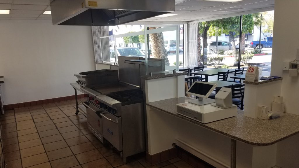 A restaurant kitchen with a counter and a cash register.