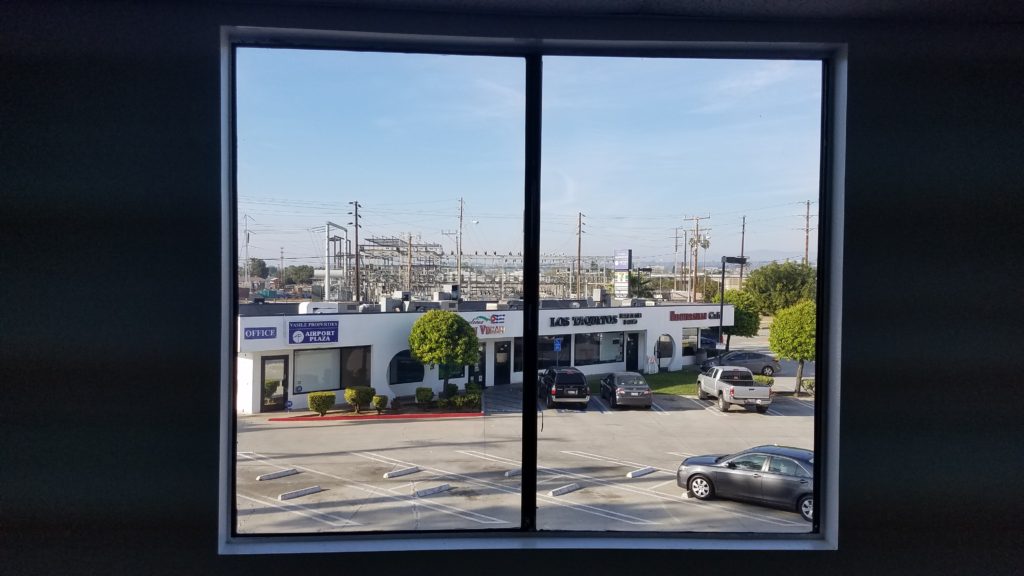 A view of cars parked in front of some stores.