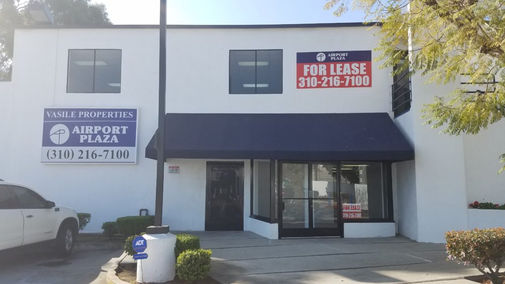 A building with for lease signs on the front of it.