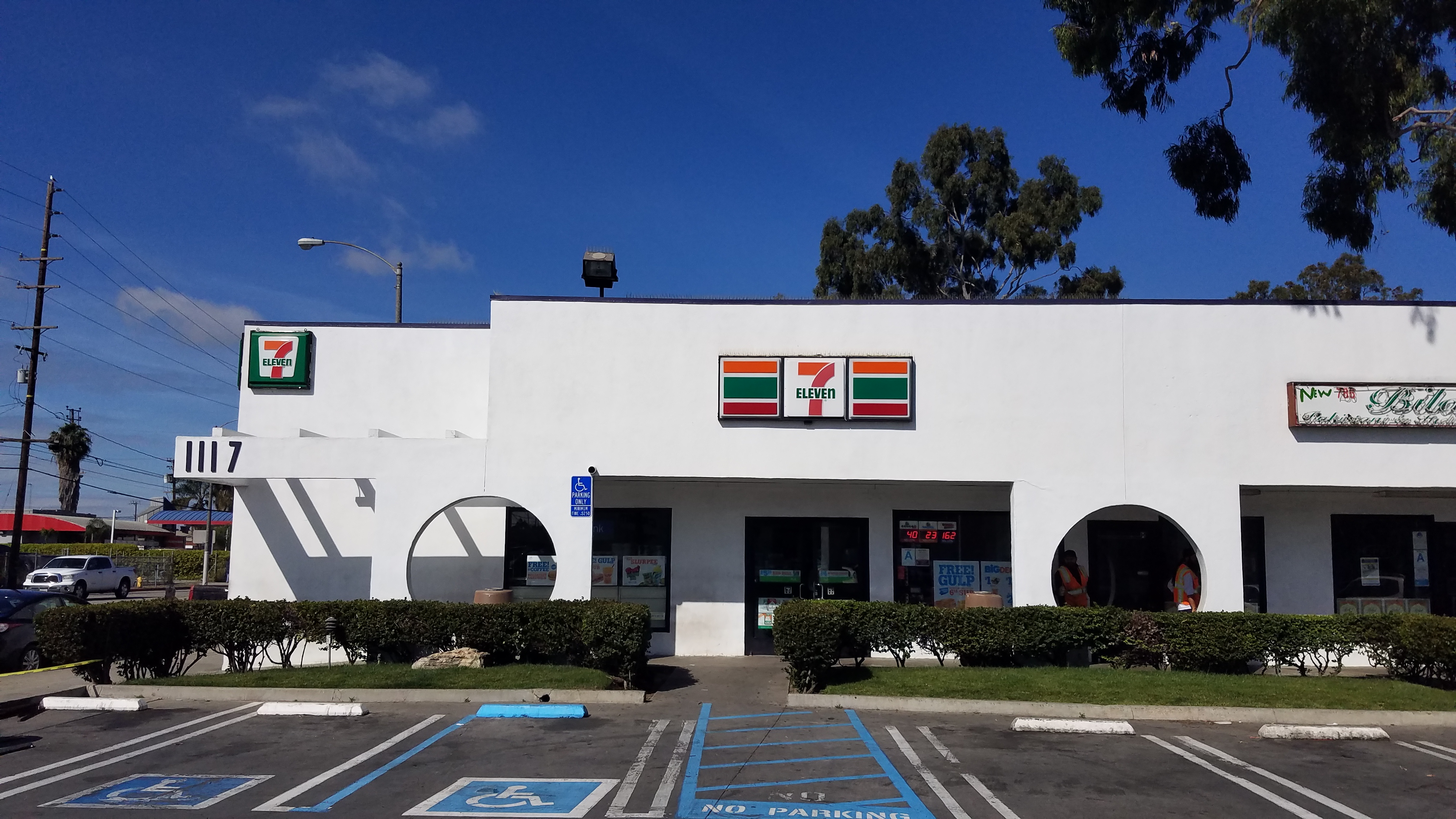 A white building with a 7-eleven sign on the front.